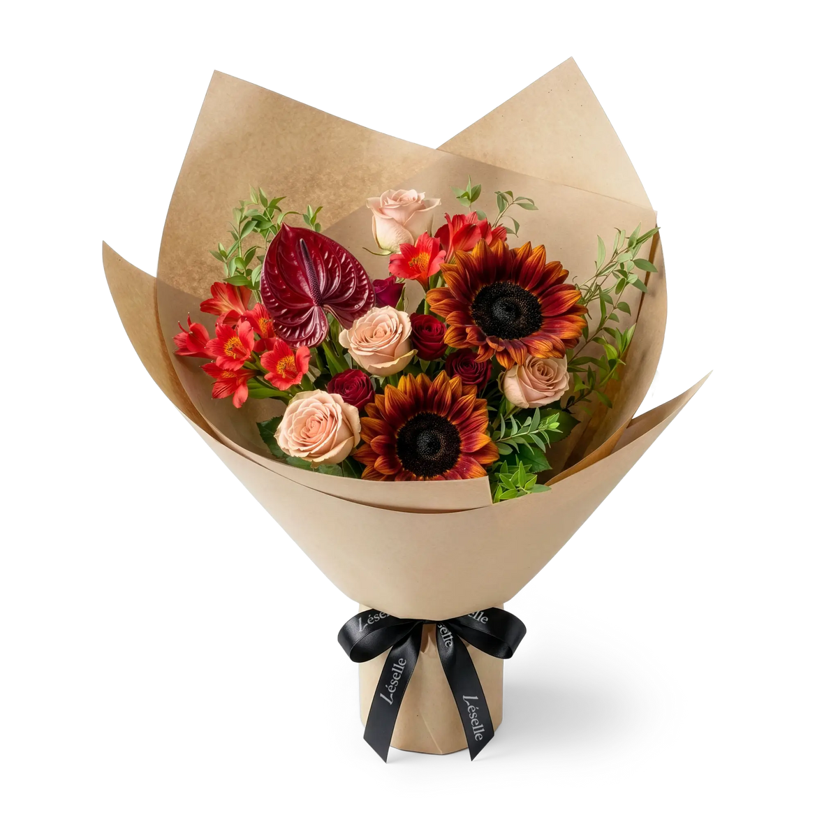A wrapped flower bouquet featuring burgundy sunflowers, cappuccino roses, a dark red anthurium, and green foliage, wrapped in a camel paper sleeve with a black ribbon, on a transparent background.