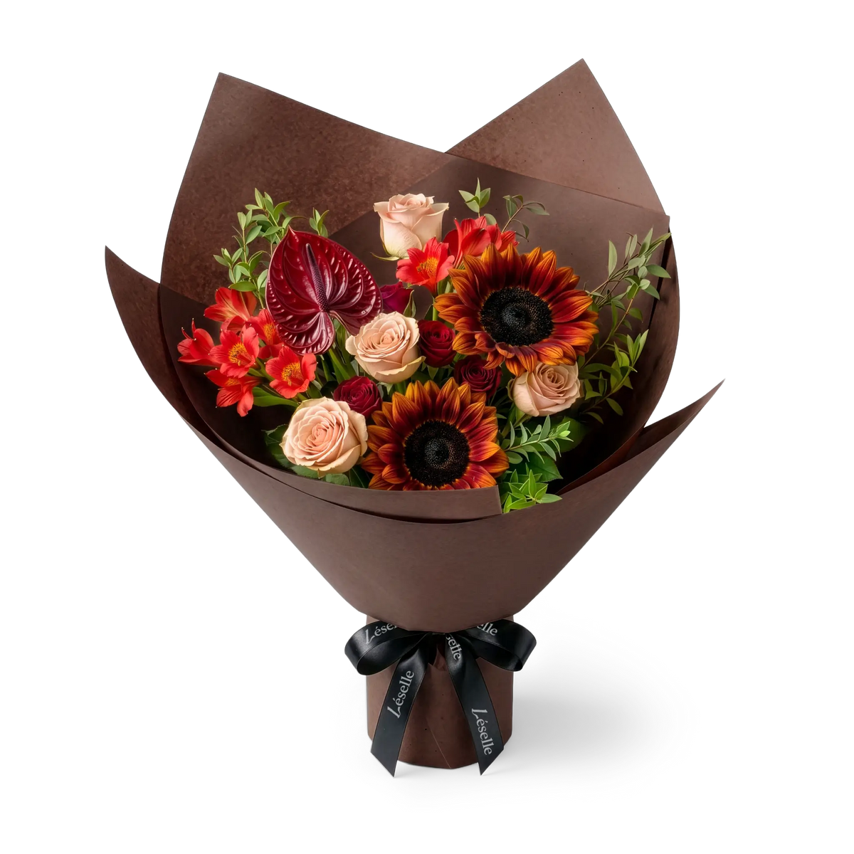 A wrapped flower bouquet featuring burgundy sunflowers, cappuccino roses, a dark red anthurium, and green foliage, wrapped in a chocolate paper sleeve with a black ribbon, on a transparent background.